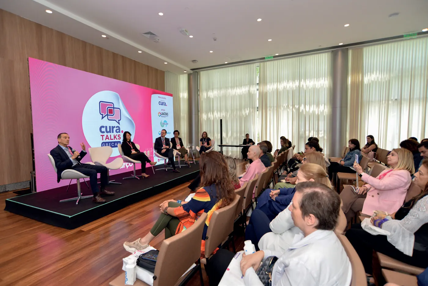 CURA Talks GBECAM, com debatedores no palco